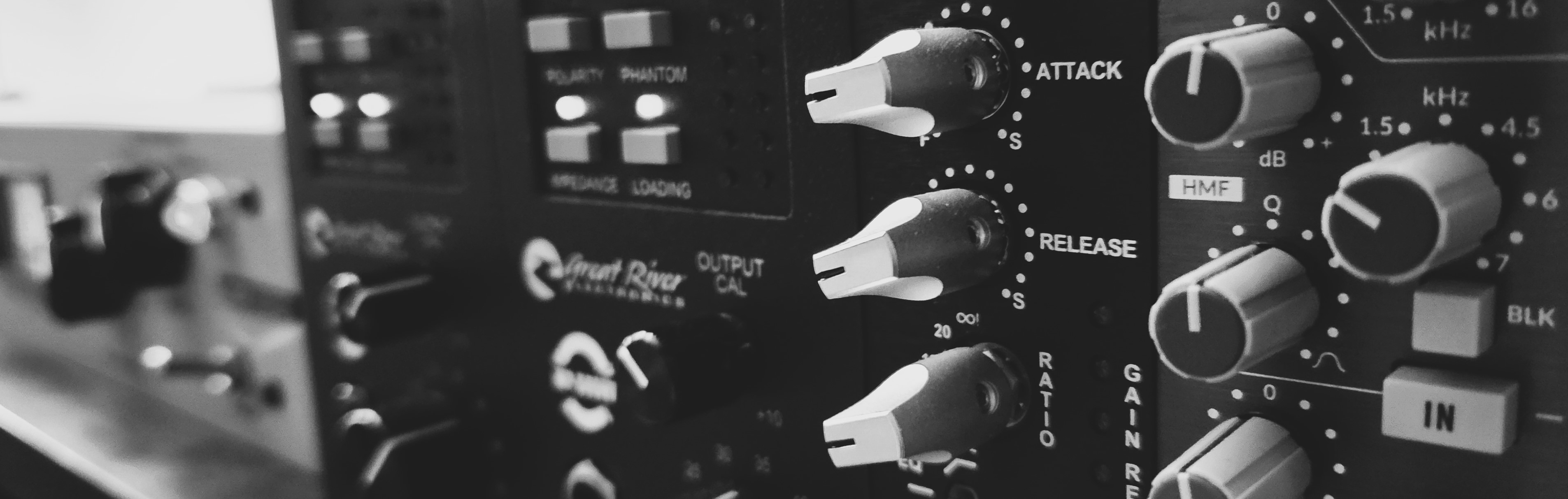 Warm Black & White Photo of Dylan at mixing desk in the Pine Cone Sound studio.